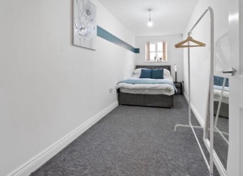 a bedroom with a bed in a white room at Poets Court in West Bromwich