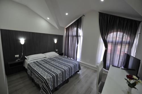 a hotel room with a bed and a window at Rose Garden Hotel in Shkodër