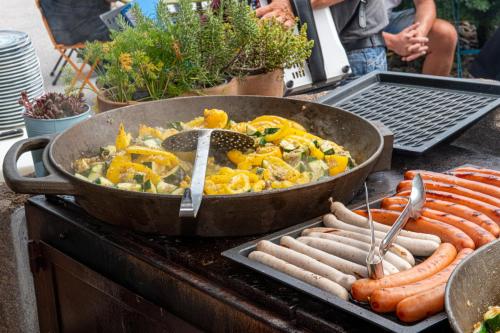 a grill with a bunch of hot dogs and sausages at ALPENHOTEL TYROL - B&B - ADULTS ONLY - Alpines Lifestyle-Konzepthotel - dog friendly in Pertisau