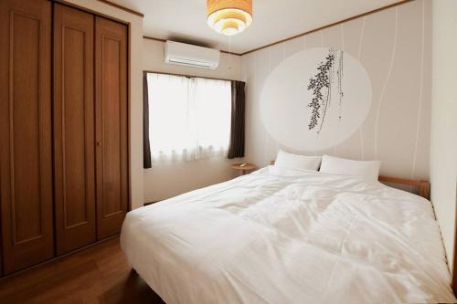 a bedroom with a white bed and a window at Largo in Tokyo