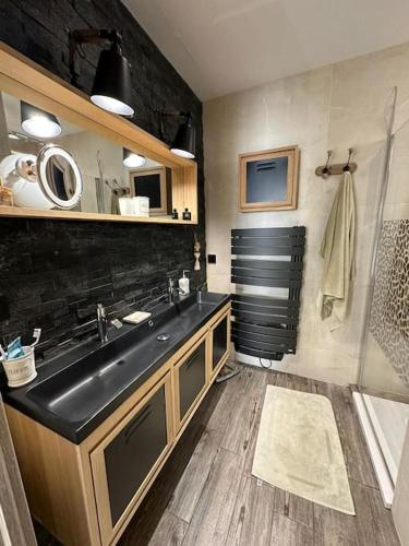 La salle de bains est pourvue d'un lavabo noir et d'une douche. dans l'établissement Maison avec piscine et cottage, à Roquebrune-sur Argens