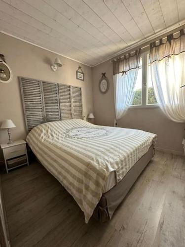 une chambre avec un grand lit et deux fenêtres dans l'établissement Maison avec piscine et cottage, à Roquebrune-sur Argens