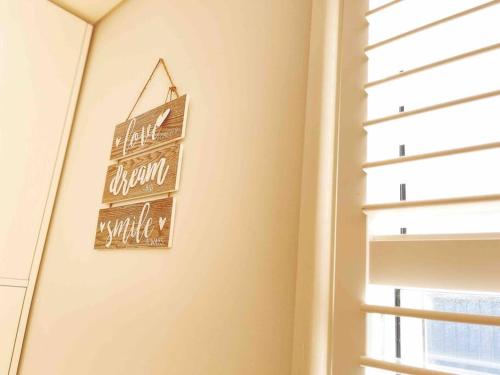a sign hanging on a wall next to a window at Palm Rest - 2BR Beachside Escape On Towradgi Beach in Towradgi