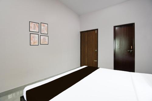 a bedroom with a bed and two doors at Super Hotel O MNJ Mansion in Bhubaneshwar