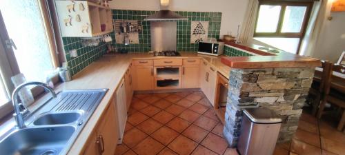 une cuisine avec un évier et un plan de travail dans l'établissement Tony gîte chelou, à Lanslevillard