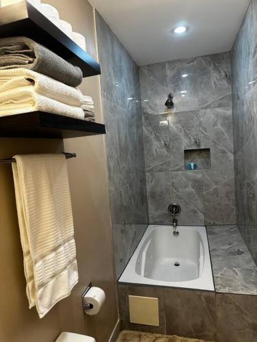 a bathroom with a tub and a shower with towels at Townhouse in Baltimore in Baltimore