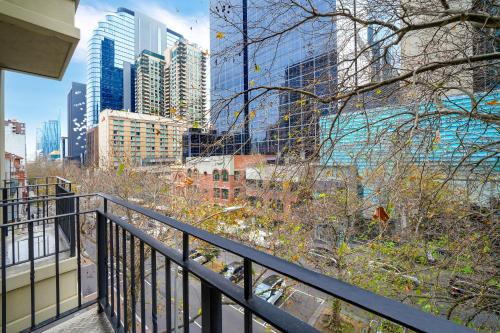 a balcony with a view of a city at Comfort Apartments Melbourne Central in Melbourne