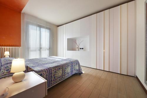 ペスキエーラ・デル・ガルダにあるCasa vacanze da riki appartamento 3のベッドとランプ付きのテーブルがある寝室