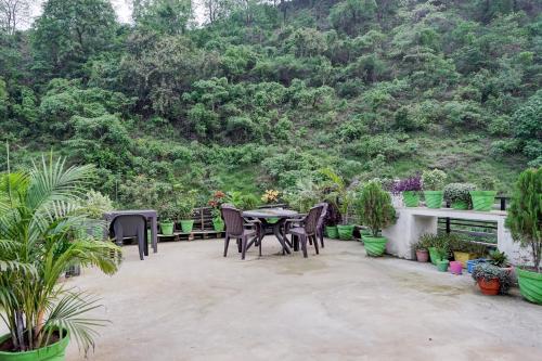 a patio with a table and chairs in front of a mountain at Hotel Aradhana palace in Rishīkesh