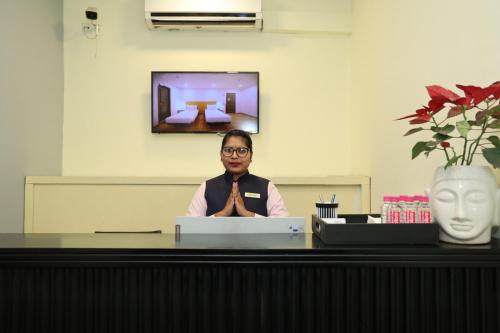 a man sitting at a desk with a laptop at Crayon Hotels in Gandhinagar