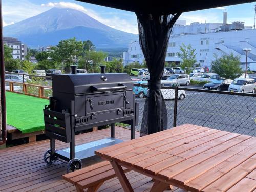 a grill on a deck with a table and a mountain at Vacation Stay Fuji - 桜館 in Fujikawaguchiko
