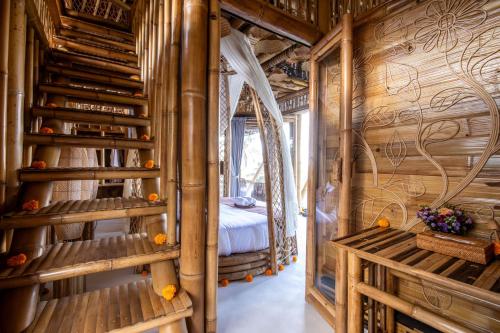 a room with wooden walls and stairs with a bed at Magic Hills Bali - Eco Luxury Adventure in Karangasem