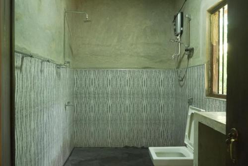 a bathroom with a shower and a sink and a toilet at Samudra resort polonaruwa Road in Habarana