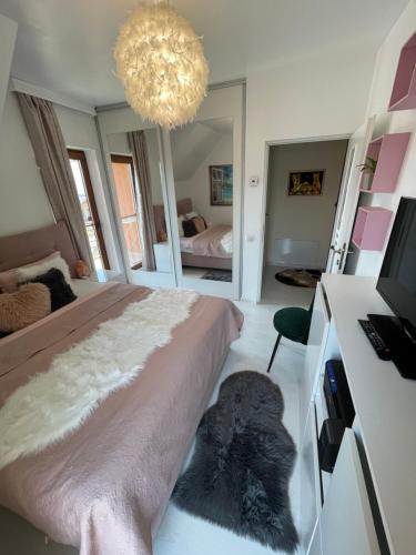 a bedroom with a large bed and a chandelier at Garsonierǎ la curte cu ciubǎr in Cluj-Napoca