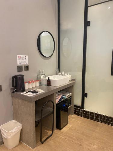 a bathroom with a sink and a toilet and a mirror at Rest Chinatown Hotel in Singapore