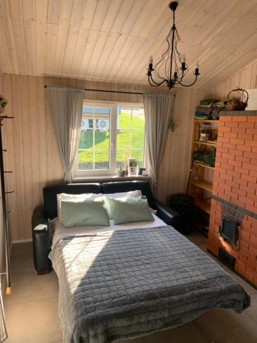 a bedroom with a large bed and a window at Pirties namelis Paliekys in Lekėčiai