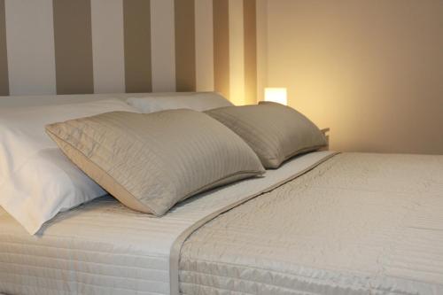 a white bed with two pillows on top of it at BSuites Apartment in Padova