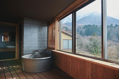 a bathroom with a tub and a large window at ITADAKI Daisen 大山参道ホテル頂 in Daisen