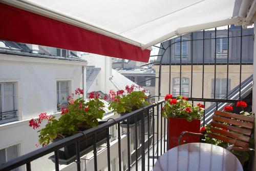 - un balcon avec des fleurs et des plantes dans un bâtiment dans l'établissement Grand Hôtel Dechampaigne, à Paris