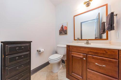 a bathroom with a toilet and a sink and a mirror at Spacious Penthouse ON the Broadway Strip in Nashville
