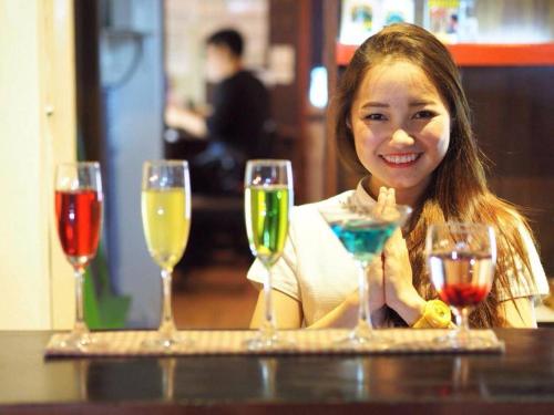 a woman sitting at a table with four wine glasses at Vieng Mantra Hotel in Chiang Mai