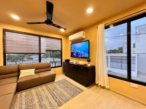 a living room with a couch and a flat screen tv at Depa Palenque I Cancun in Cancún