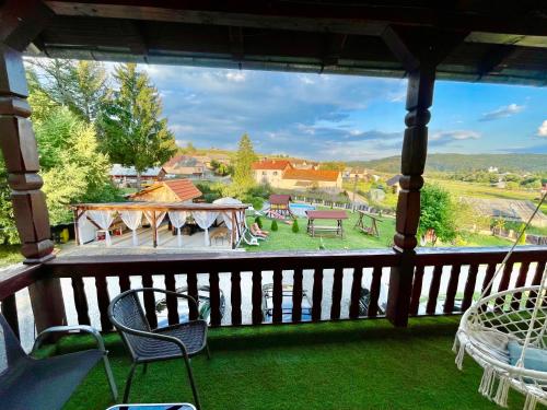 a view of a porch with chairs and a table at Pensiunea Beatrice in Întorsura Buzăului