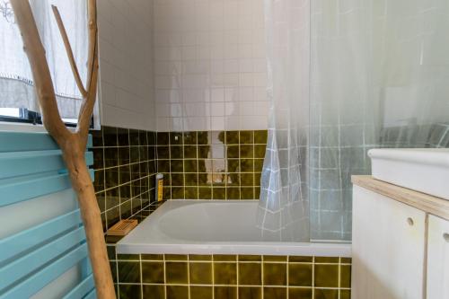 une salle de bain avec une baignoire et un lavabo dans l'établissement Cosy et Lumineux Métro Ligne 9, à Montreuil