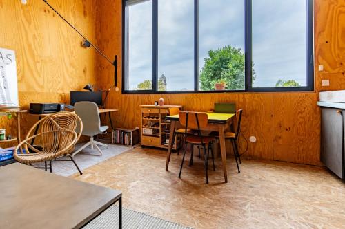 une pièce avec une table, des chaises et des fenêtres dans l'établissement Cosy et Lumineux Métro Ligne 9, à Montreuil