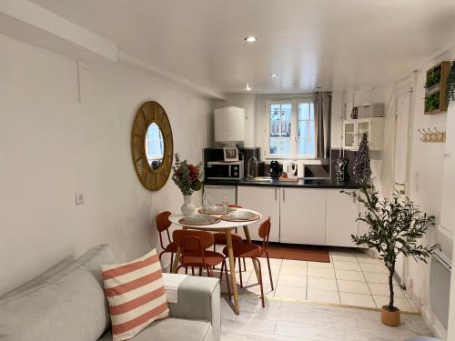 Il comprend un salon et une cuisine avec une table et des chaises. dans l'établissement Le Cocon du Panthéon, à Paris