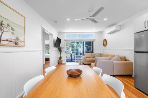 a kitchen and living room with a wooden table and a couch at BIG4 Tasman Holiday Parks - Ballina in Lennox Head