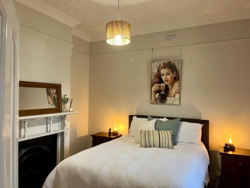 a bedroom with a bed with a fireplace and a mirror at Cottage on Manilla - Bathurst - Centrally located in Bathurst