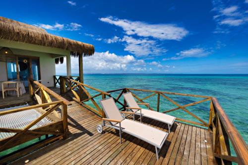 a resort deck with chairs and the ocean at Bawe Island Zanzibar in Zanzibar City