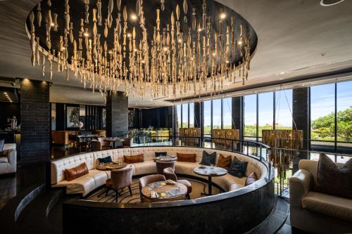 a hotel lobby with a large chandelier at The Capital Zimbali in Ballito