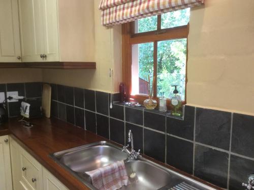 a kitchen with a sink and a window at Chalet de Vin in Franschhoek
