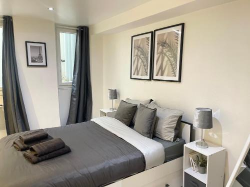 une chambre avec un lit et deux tableaux au mur dans l'établissement Le Cocon du Panthéon, à Paris