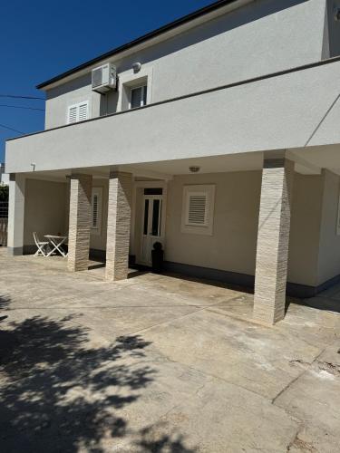 a building with awning and a patio in front of it at Beach House Murter in Murter