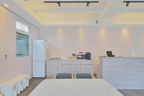 a kitchen with a table and chairs and a refrigerator at OwlStay Green Villa in Pinghe
