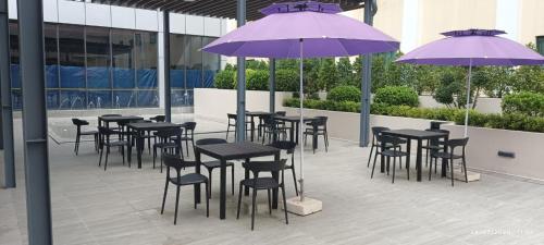 a group of tables and chairs with purple umbrellas at Summit Parkview Yangon in Yangon