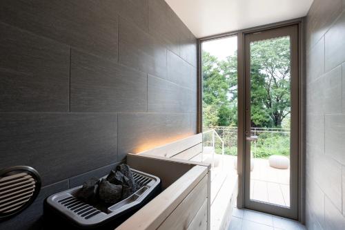 a bathroom with a bath tub and a window at Smart Villa Hakone Gora - Smart Villa 箱根強羅 in Hakone