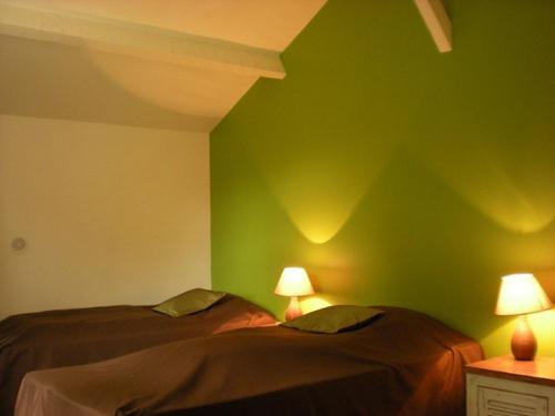 two beds in a room with green walls at Ronsard in Bonnes