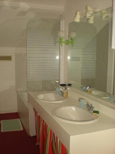 a bathroom with two sinks and a mirror at Ronsard in Bonnes