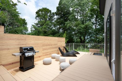a patio with a bbq and chairs and a grill at Smart Villa Hakone Gora - Smart Villa 箱根強羅 in Hakone