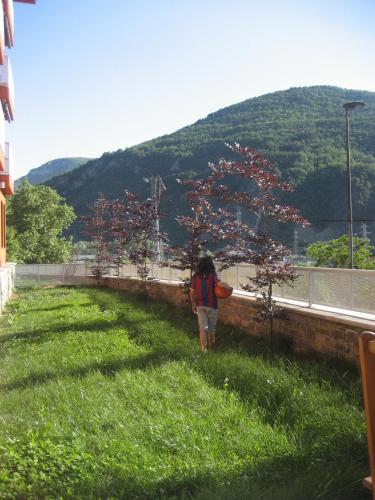 a person walking in the grass near a hill at La Faiada in El Pont de Suert