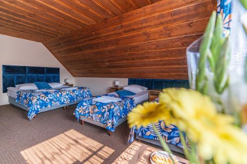 a room with two beds and a wooden ceiling at Markowy Dworek in Białka Tatrzańska
