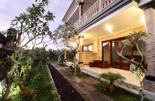 a house with a porch with a bench in the yard at Eka Dwi Guest House in Gianyar
