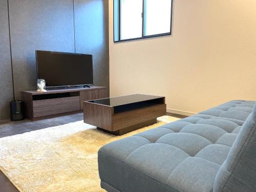 a living room with a couch and a tv at New三軒茶屋ハウス 渋谷まで電車5分 三軒茶屋駅徒歩6分 2023年フルリノベ戸建 in Tokyo
