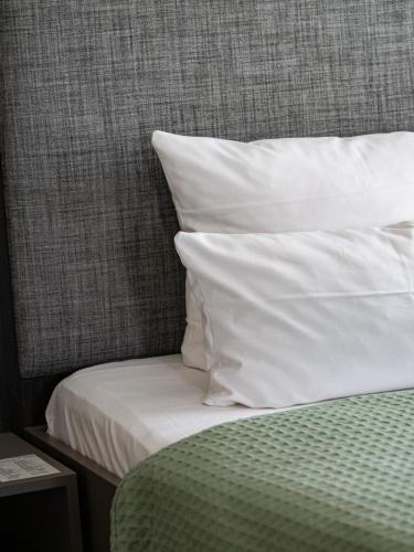 a bed with white sheets and pillows on it at Hotel Sonne in Rheda-Wiedenbrück