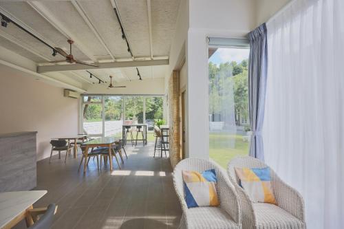 a living room with chairs and a table and a window at OwlStay Green Villa in Pinghe