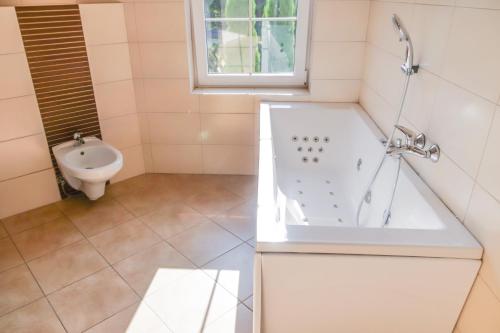 a bathroom with a tub and a sink at Laguna Resort in Budzisław
